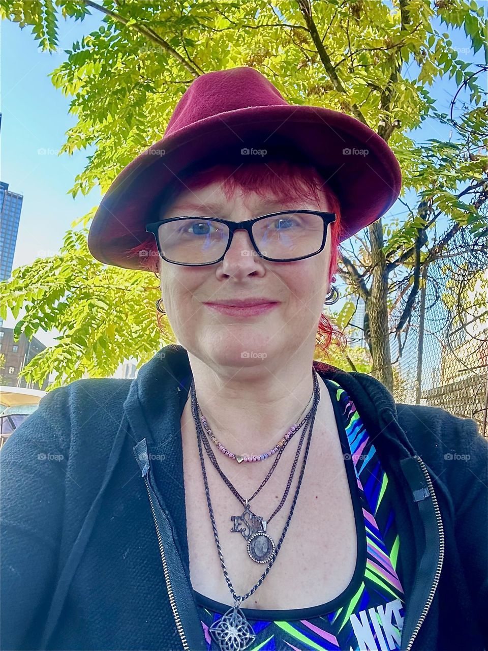 Taking a break to snap this picture this is me, “Petra Schiller” a.k.a. “Maxine Firefox” in the parking lot beneath the “Pulaski Bridge” at “Newtown Creek” in LIC, Queens in the cool weather that heralds Fall. 2024. Hypnotic Productions