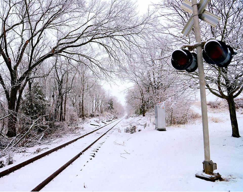 Railroad crossing in snow. Fresh fallen snow covers the railroad tracks