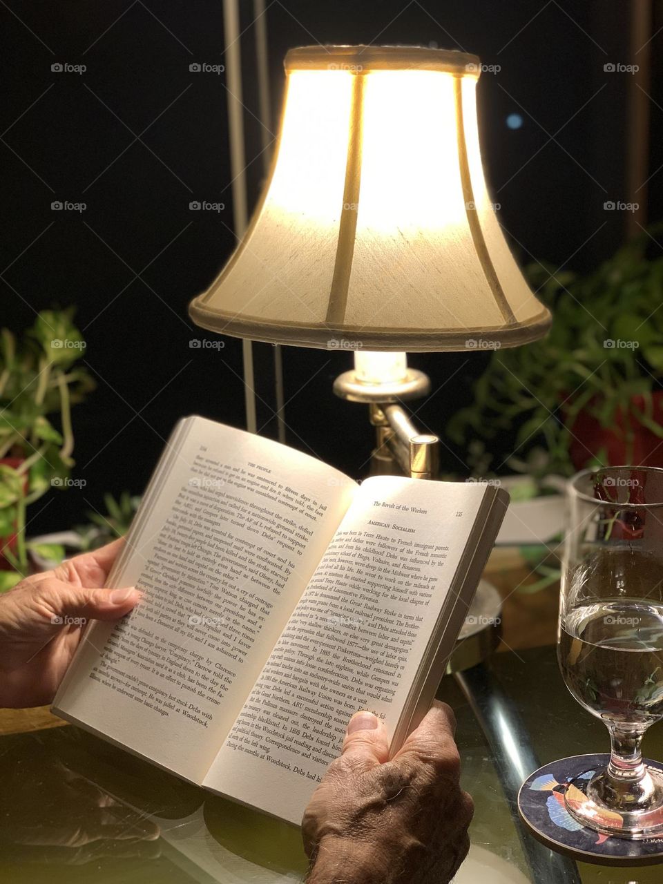 A man reading a book during night time 