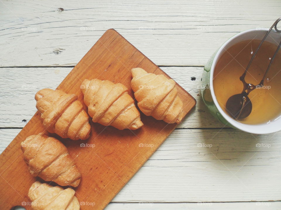 croissants and green tea on white boards