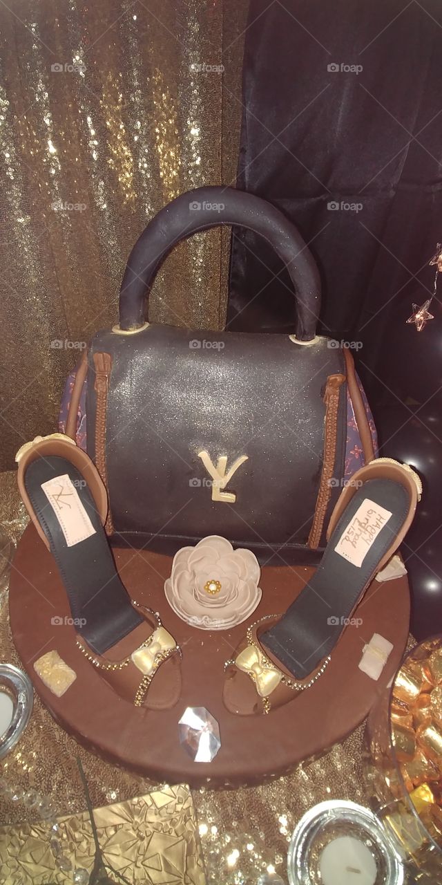 Louis Vuitton cake theme party.  Cake filling was with guava fruit very delicious. Shoes are milk chocolate. Beautiful cake done with much talent.😊