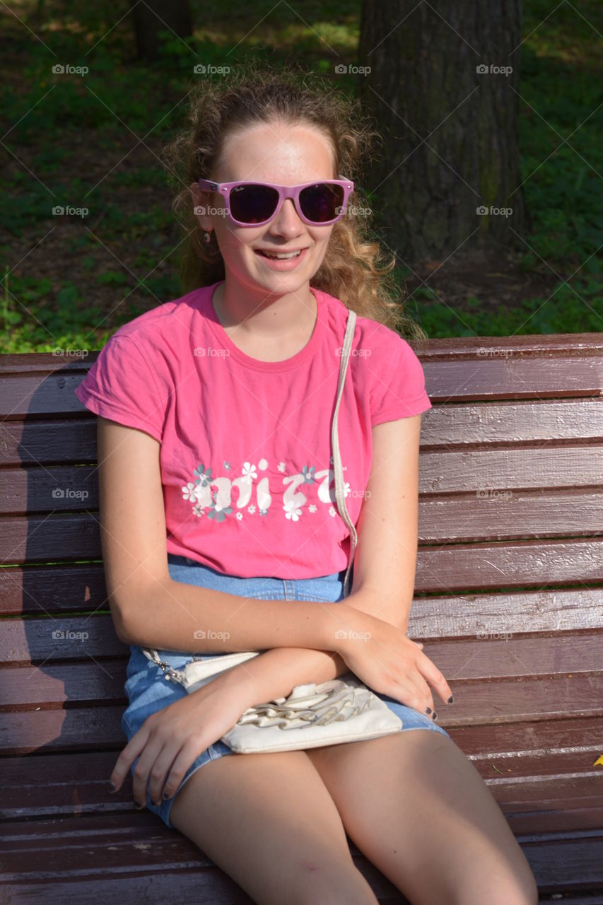 girl on a bench in the summer city park