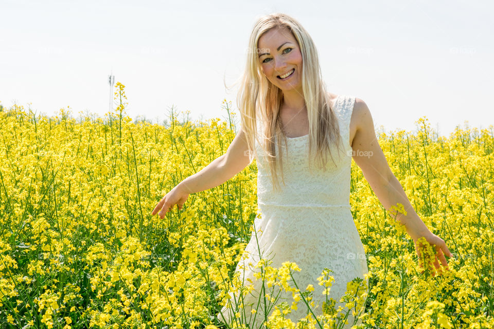 Smiling woman in yellow flower field