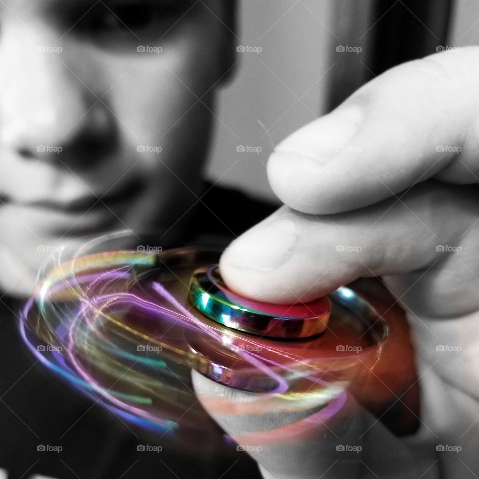 Close-up of boy playing with spinner toy