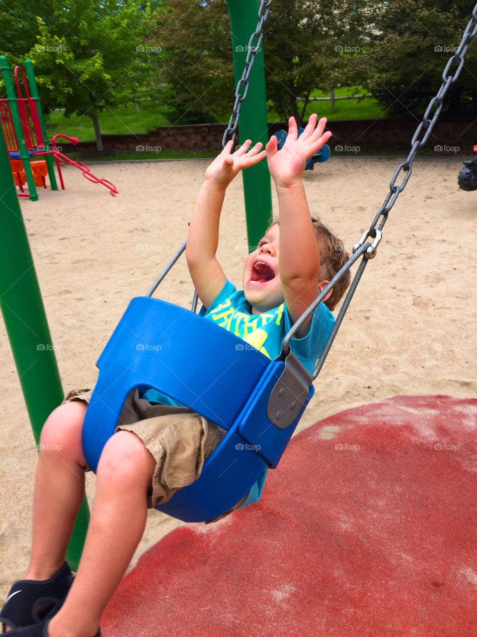 Summer Fun. Toddler swinging at the playground