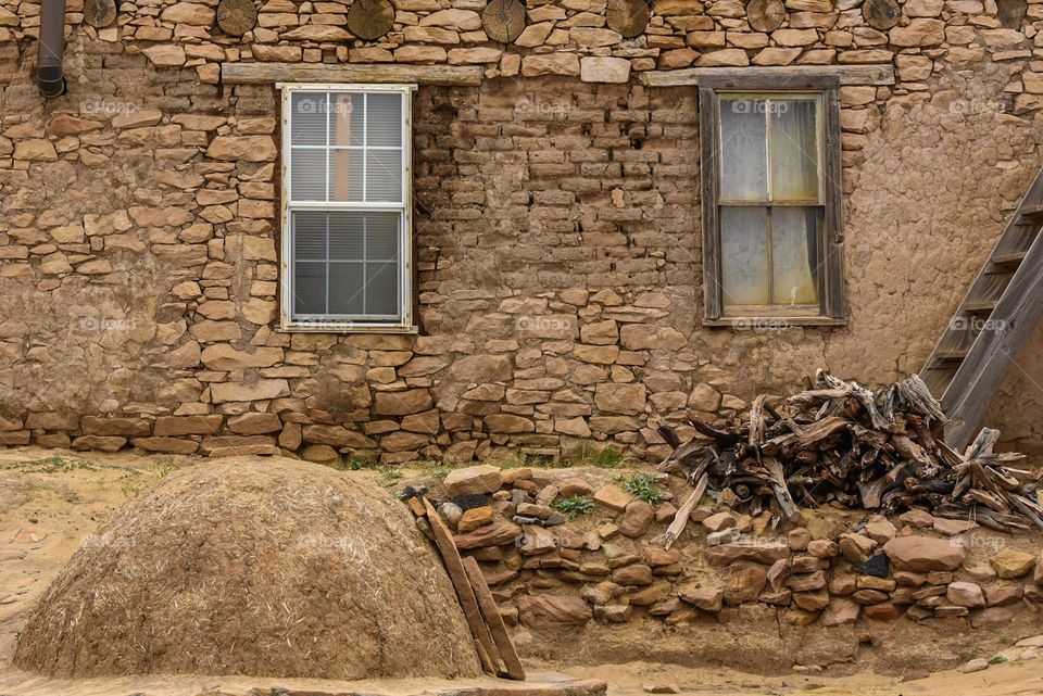 A horno in front of an Adobe house