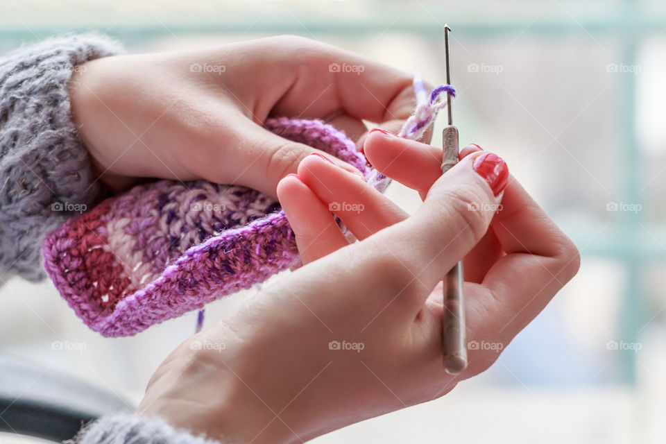 A woman crocheting in the house