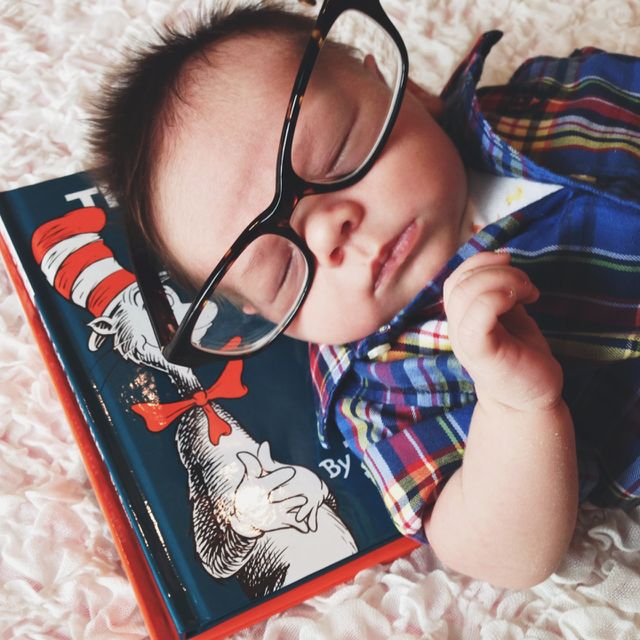 Baby in glasses with books