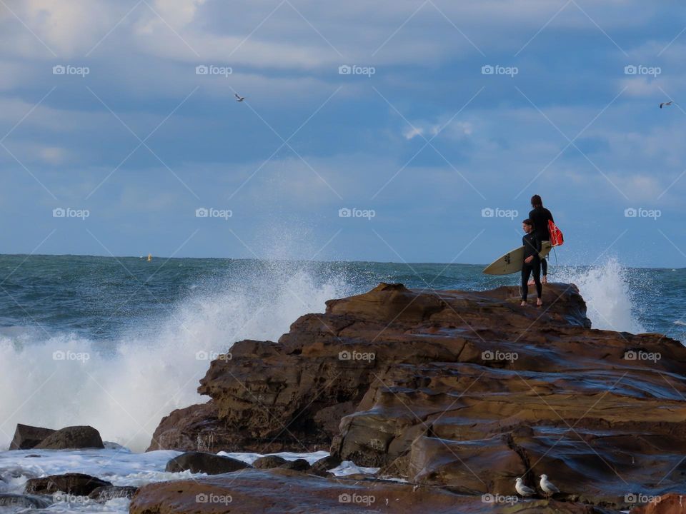 Surfers on rocks