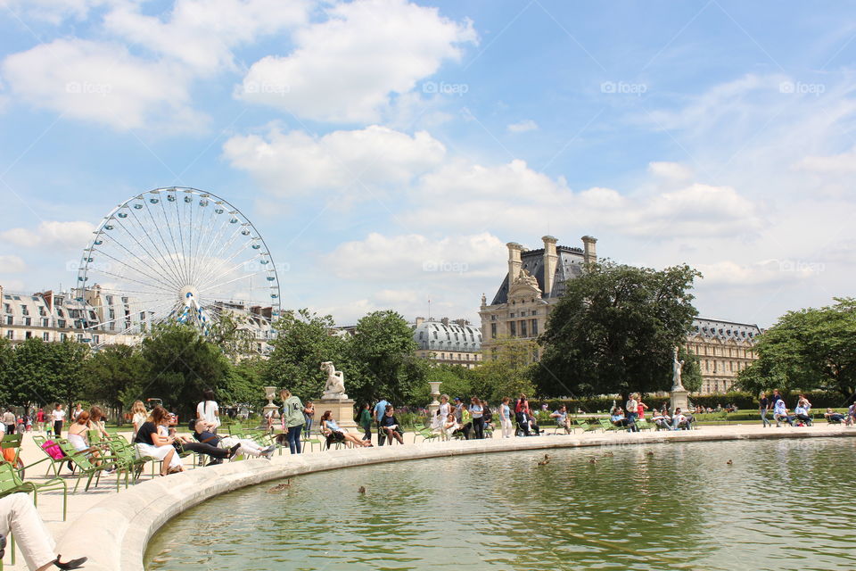 people are hanging out by the pond in Paris.