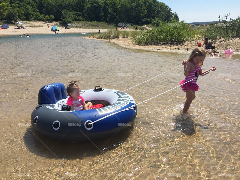 Little girls enjoying in sea with inflatable