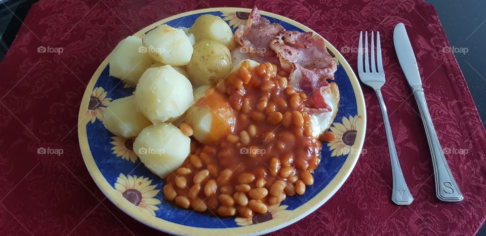 Breakfast potatoes bacon baked beans and fried eggs