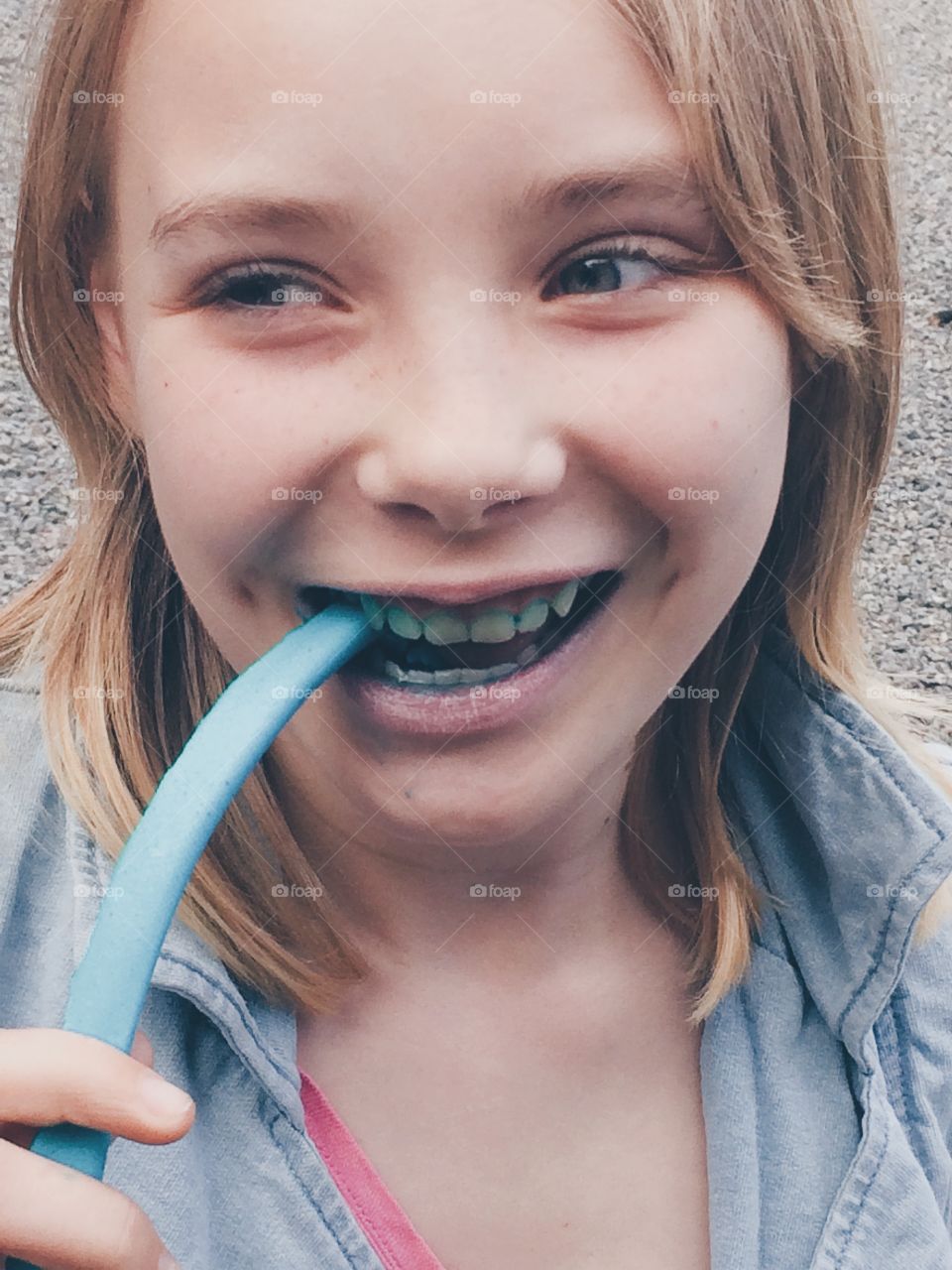 Eating candy. A girl eating blue candy