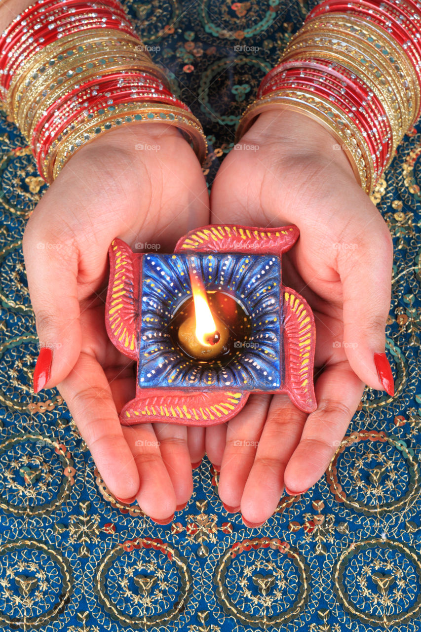 Female holding a Diwali diya in her hands