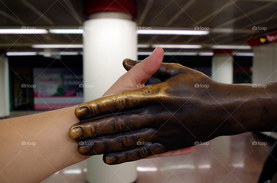 Human hand touching artificial hand in Budapest, Hungary.