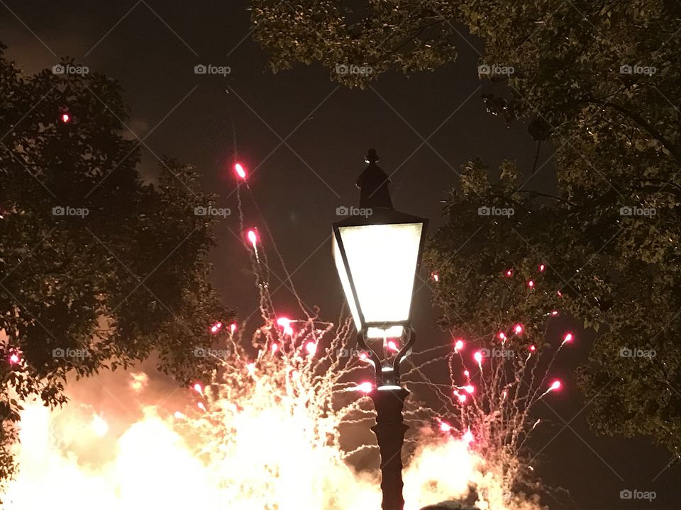 Fireworks bursting in the background of a lamp post at Epcot