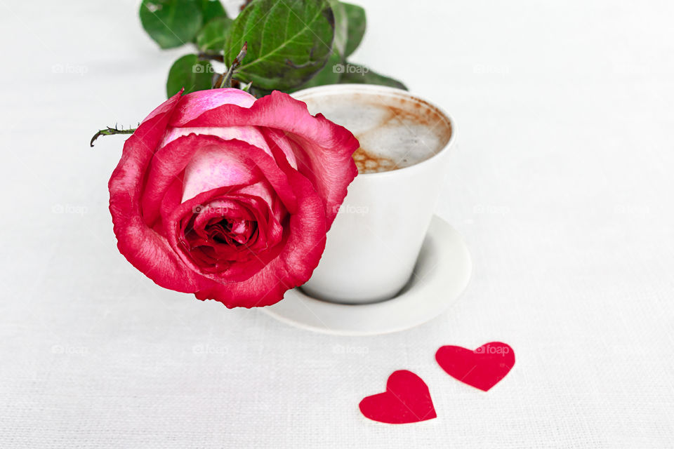 a cup of coffee and a rose