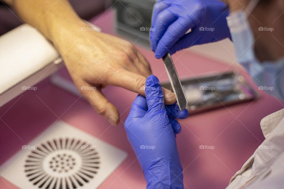 Man’s hand gets manicure in the beauty salon 