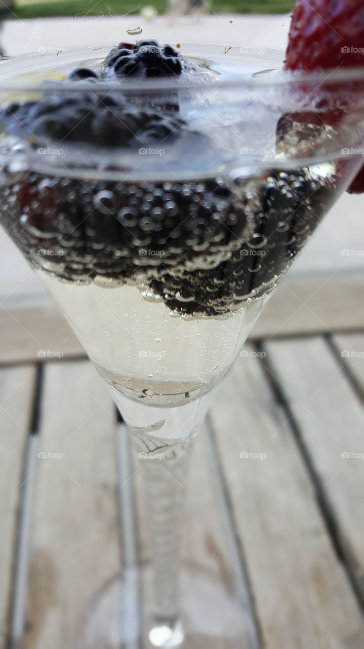 Bubbles in champagne and blackberries