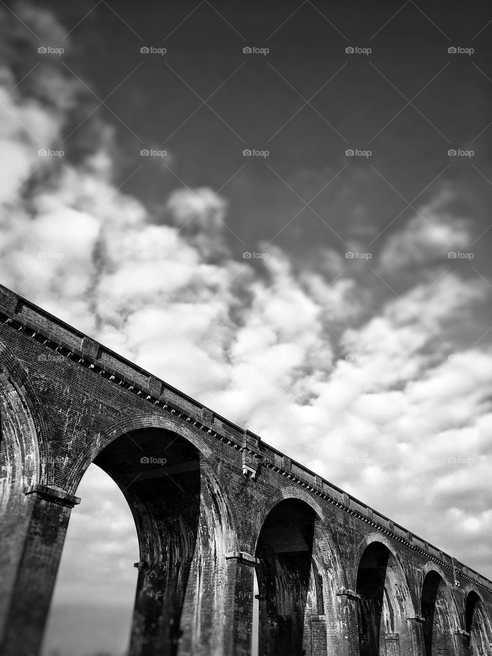 Arch bridge against cloudy sky