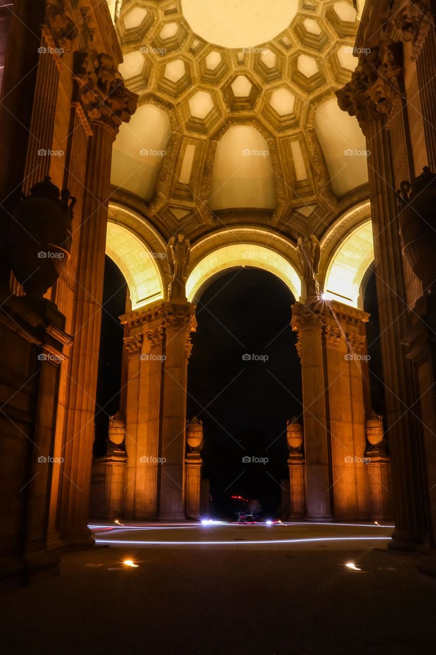 Palace of Fine Arts in San Francisco California at night under the dome with a light ring glowing at the base from motor scooters circling on a Friday night