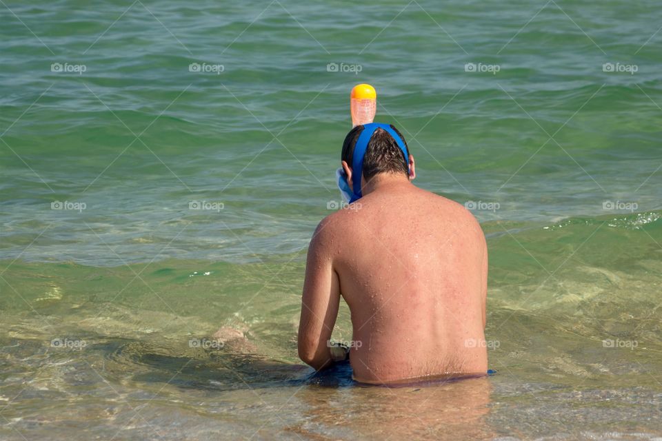 Side view of boy with swimming snorkel mask on the beach 
