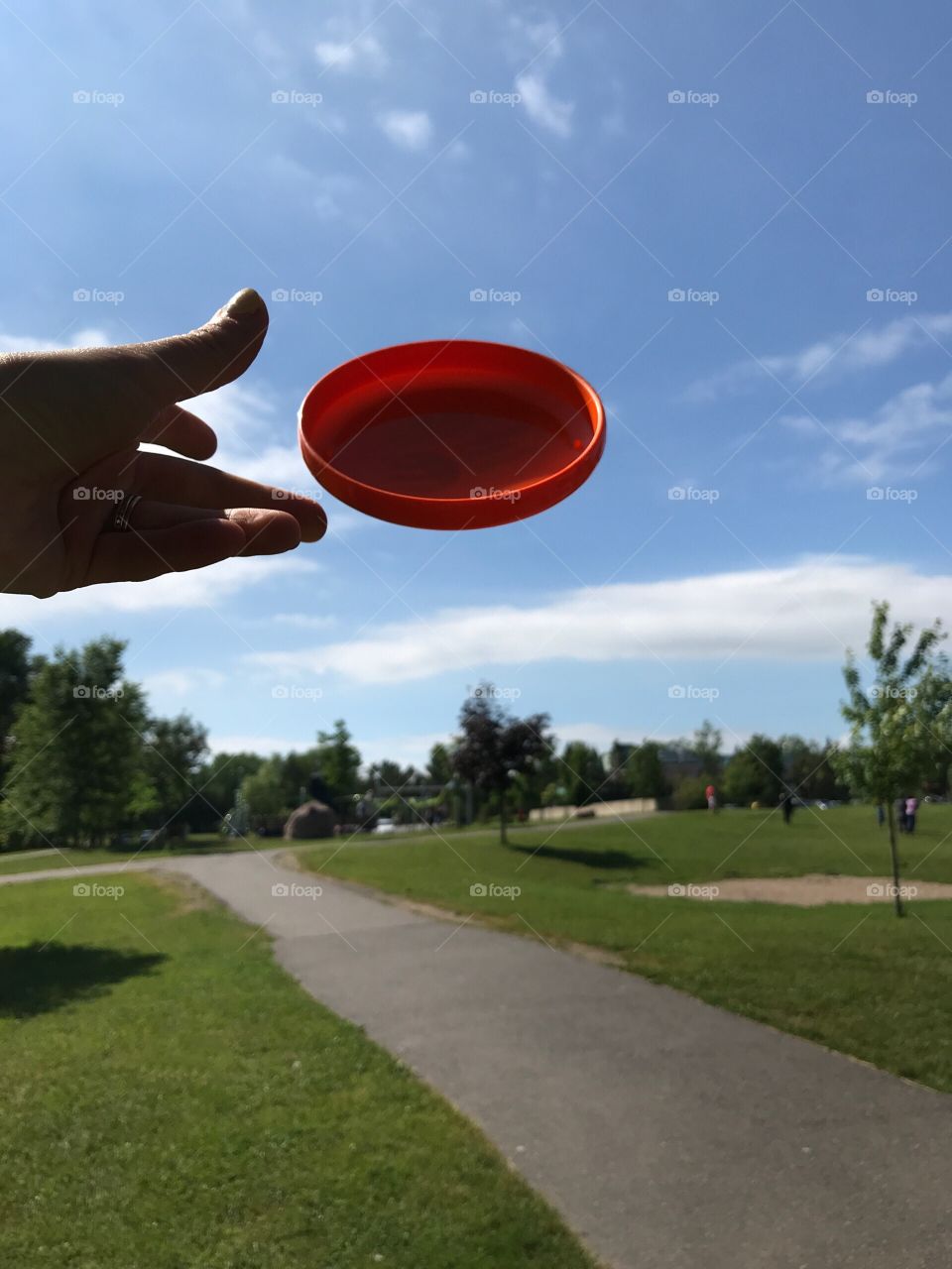 Throwing a frisbee at the park on a sunny day 