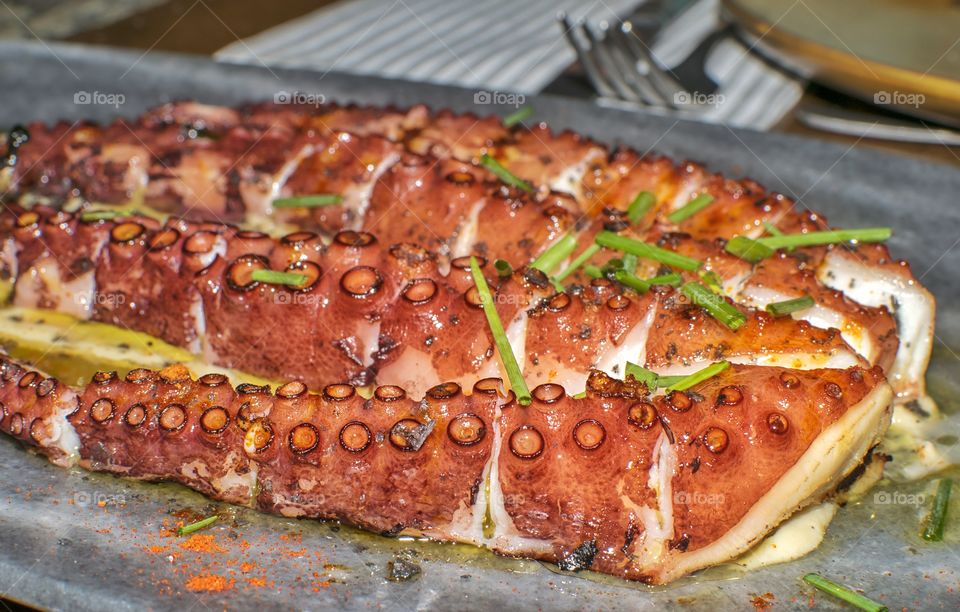 Octopus served with parsley and melted cheese