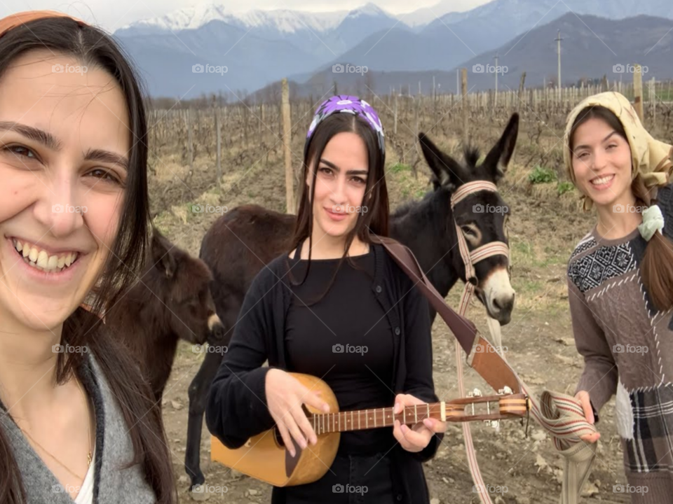 Three Girls Singing with a donkey behind