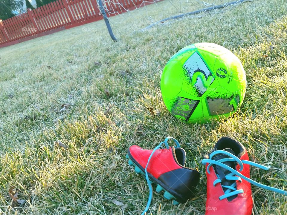 red soccer cleats and neon ball against