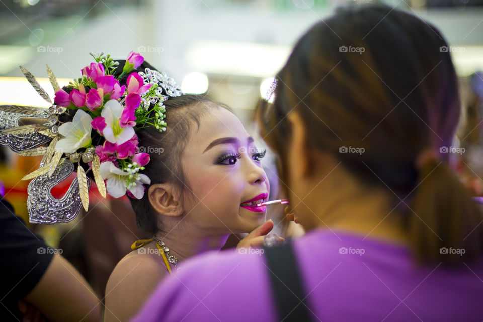 Before show time. mother putting make up on daughter prior show