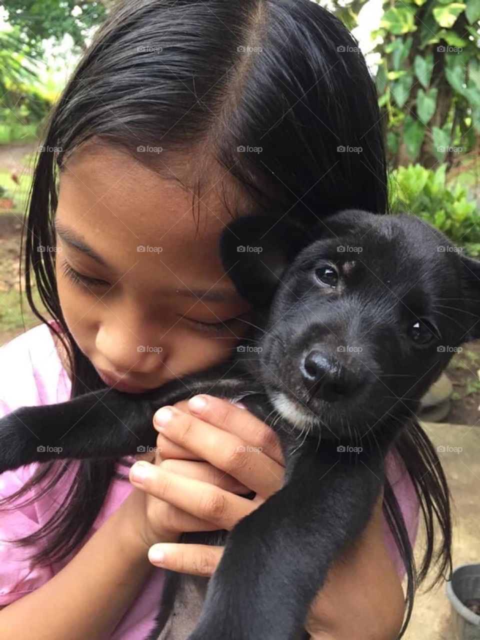 Little girl and her new black puppy 