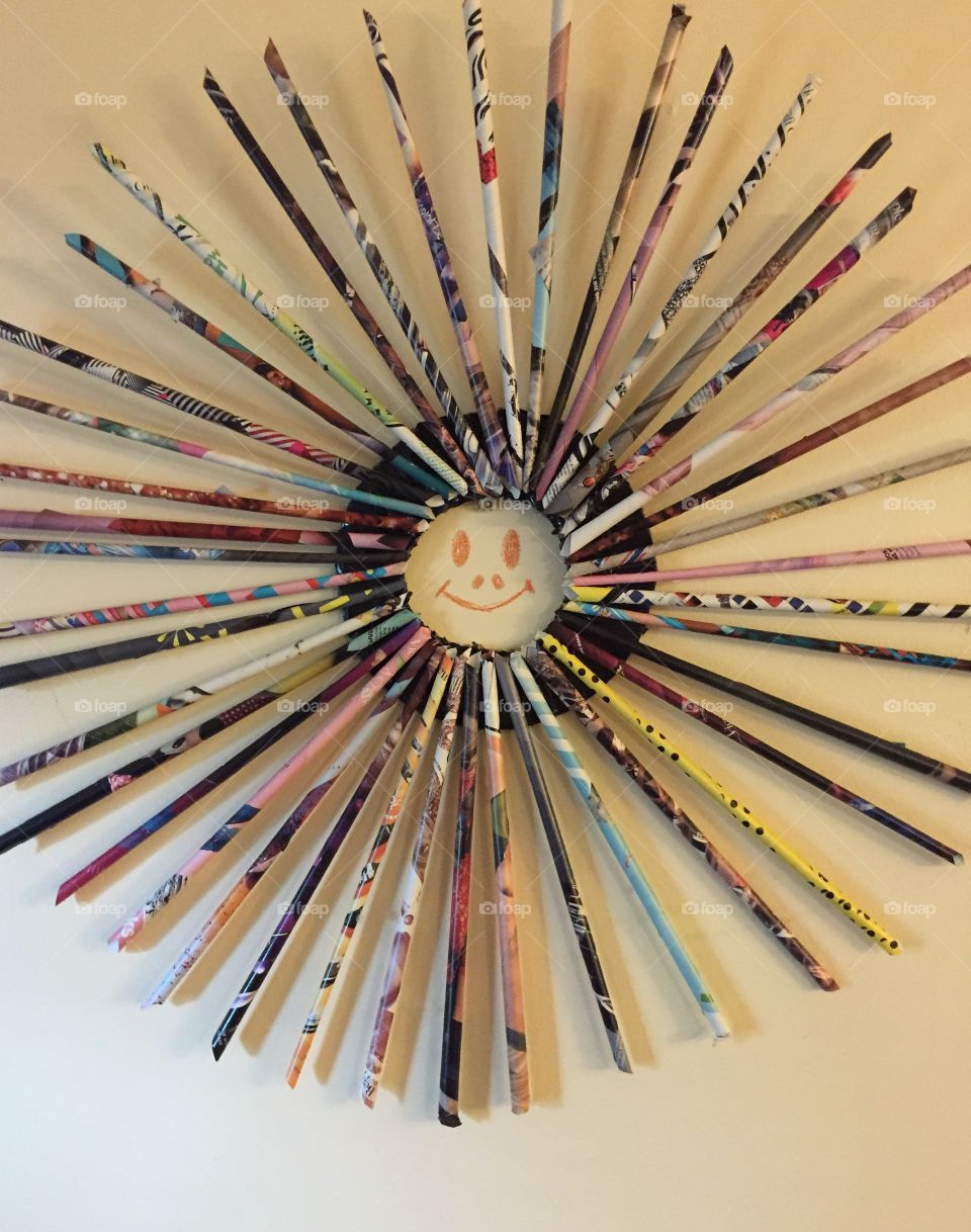 Design  looking like a wheel with spokes with a smiley face in the center.