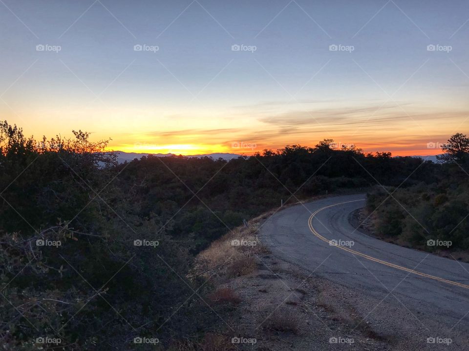 Winding road alongside a beautiful sunset