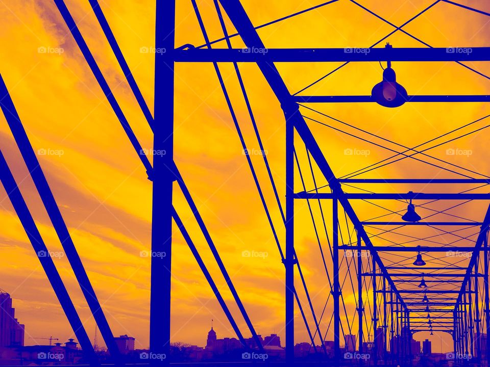 Historic bridge silhouettes with a golden yellow backdrop.