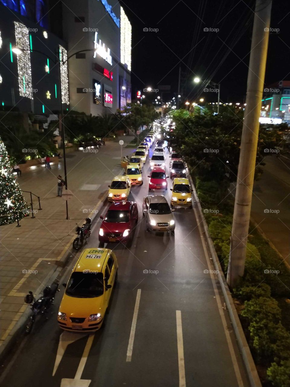 Congestionada vía en ciudad. Caos vehícular. Via angosta. Tránsito lento. Trancón.