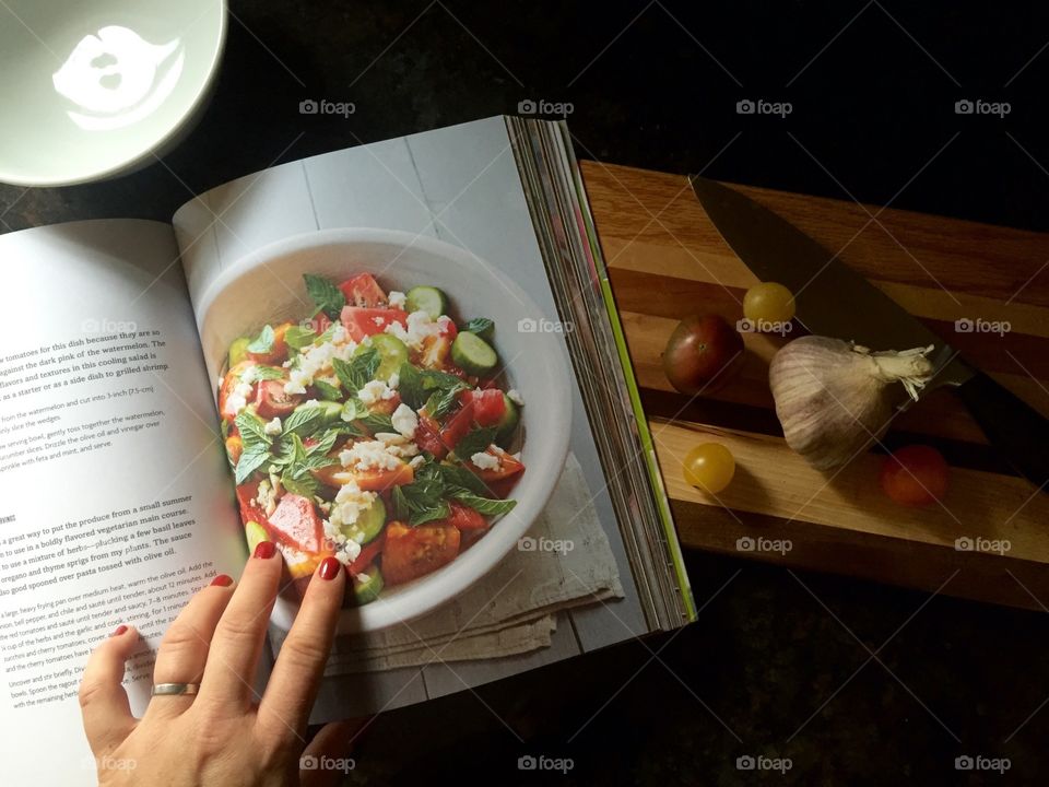 In My Kitchen. Overshot of cookbook while reading a recipe and starting to prepare a fresh dish