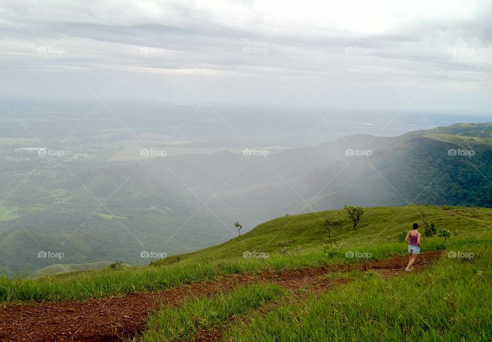A person hiking on valley in foggy weather