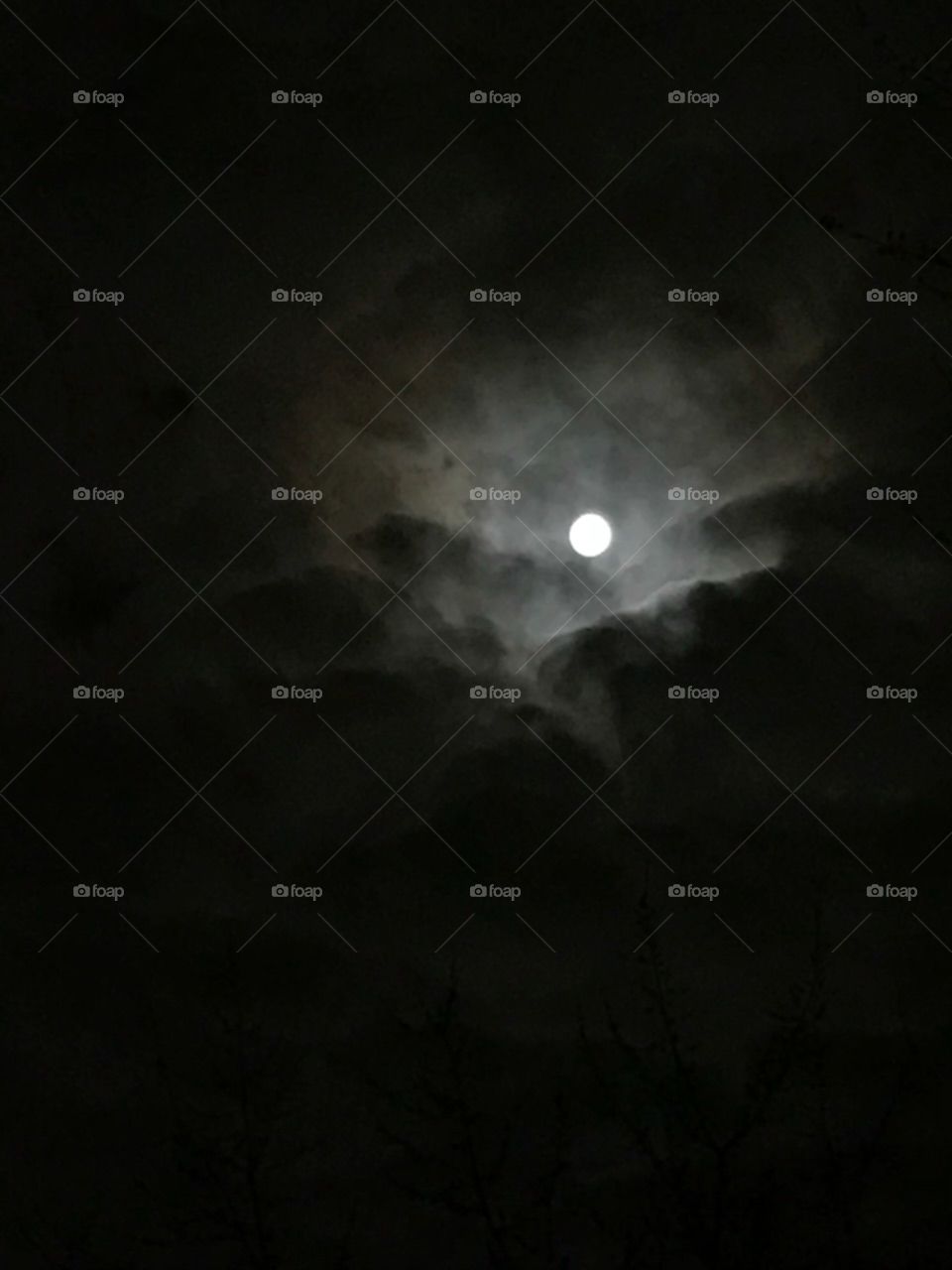 hole in the clouds showing the moon