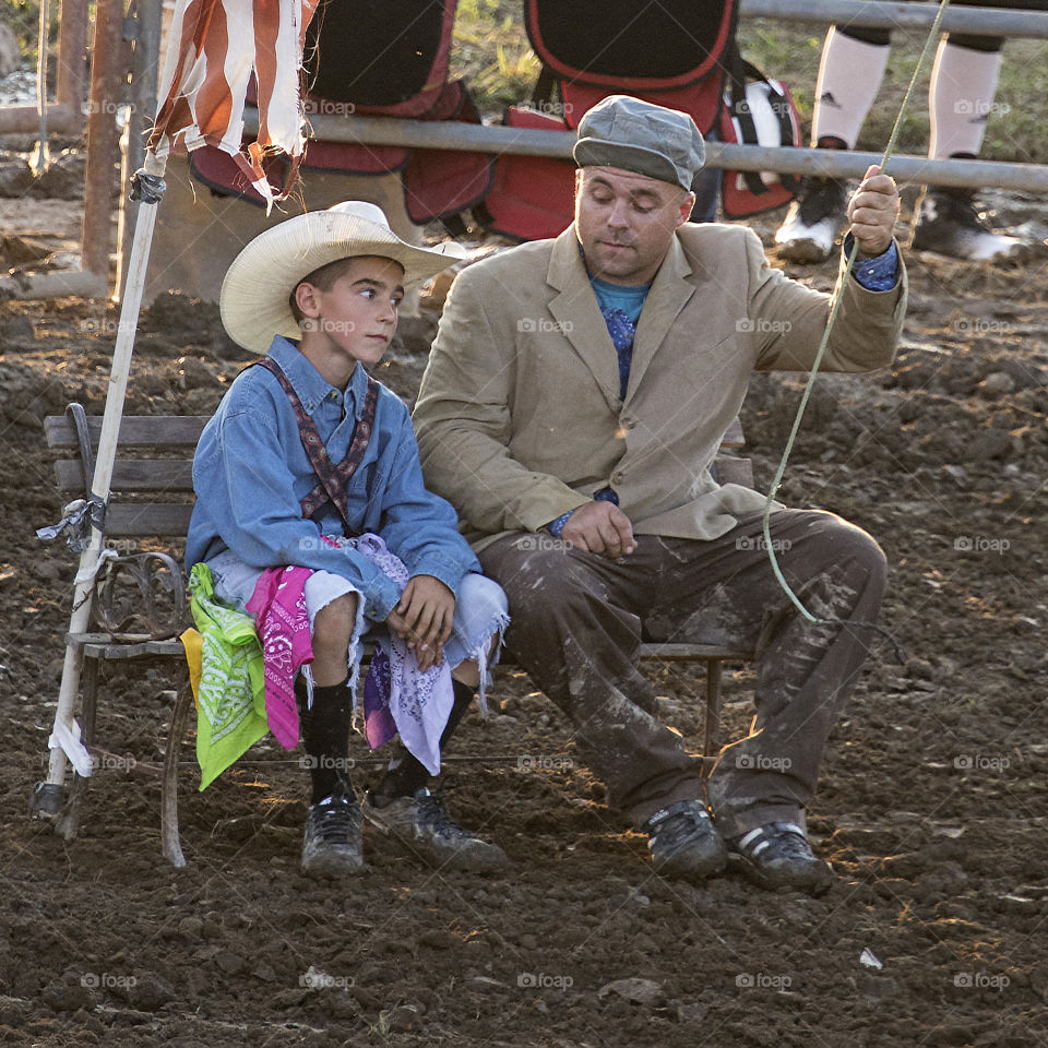 Rodeo Clowns sitting side by side during a rodeo