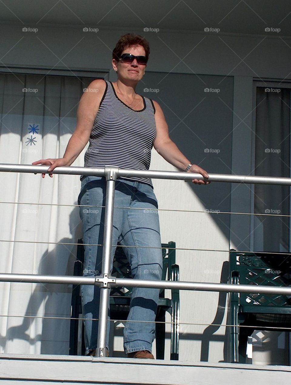 Woman wearing sunglasses holding a railing looking out