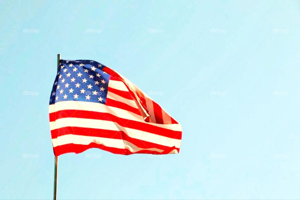 Fluttering United States of America flag against blue sky