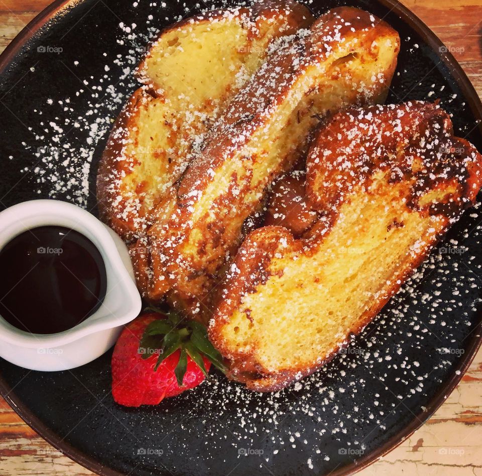 Eating French toast in a restaurant, brioche French toast, delicious meals for breakfast, indulgence at breakfast time 