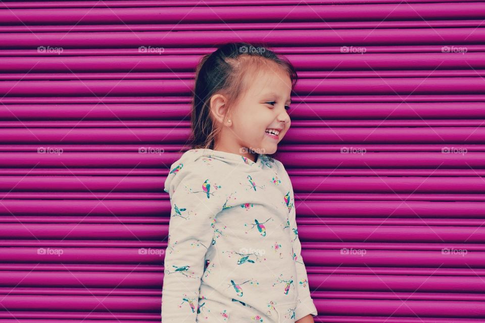 Happy little girl standing in front of shutter