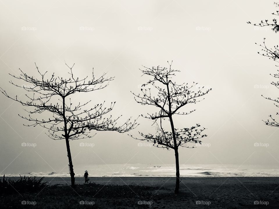 Woman/villager walking alone on the beach on a quiet winter morning in Vietnam