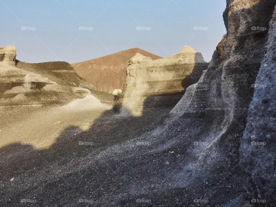paisaje volcánico con rocas, piedras y montaña de fondo en un entorno desértico y árido.