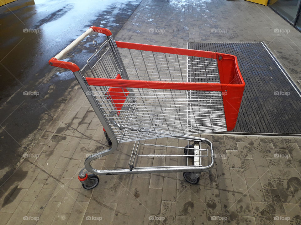 Carts for grocery products stand near a supermarket on the street