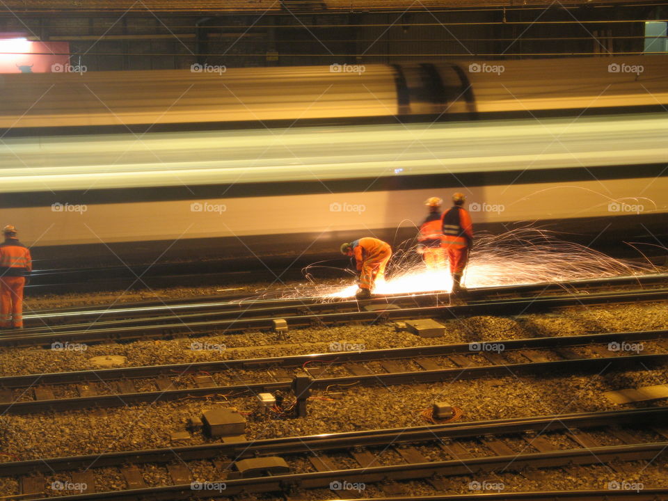 A industry workers cutting railroad matal at night