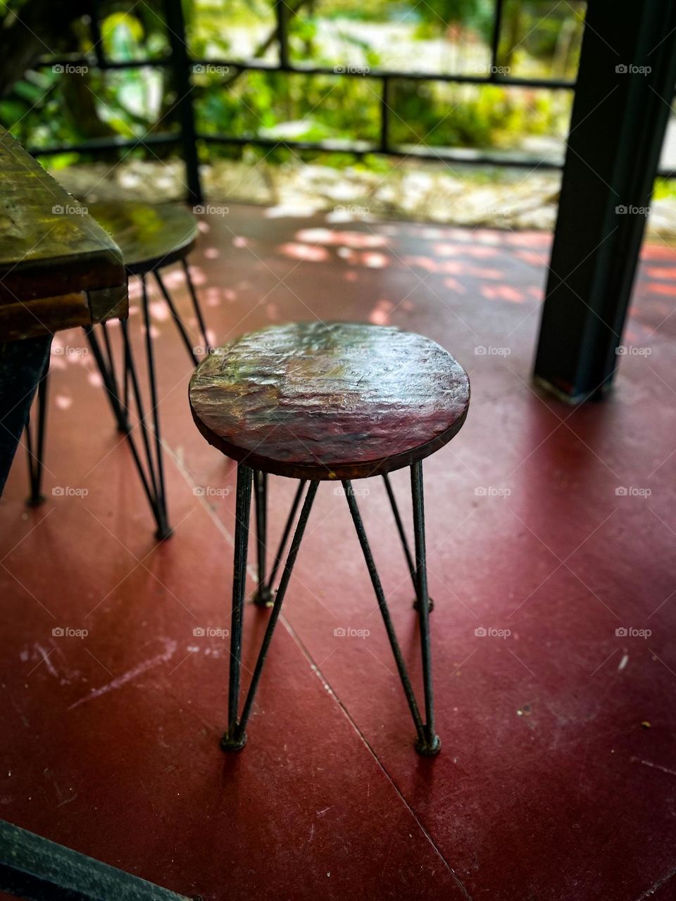 A wooden stool with iron leg in close up view