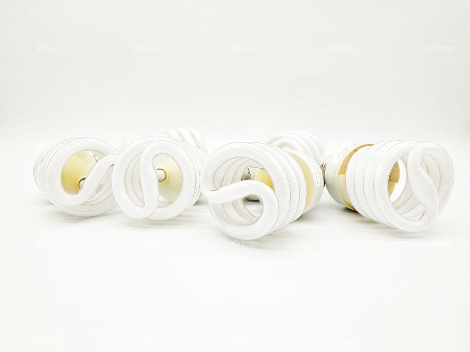 six energy-saving light bulbs lined in a row on a white background